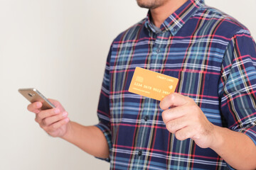 A man holding mobile phone and showing credit card