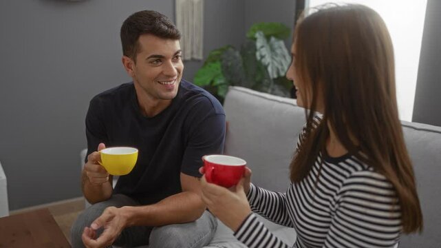 Man and woman enjoying coffee together in a cozy living room with neutral decor and a relaxed atmosphere