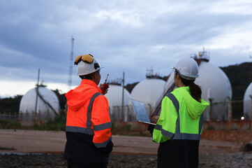 Blue-collar workers work at the oil storage field industrial site. Engineering and industrial concept.