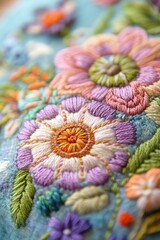 Closeup of handmade embroidery featuring intricate floral motifs in soft pastel threads,...