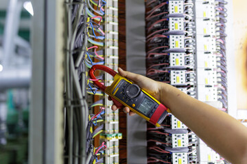 Electrical engineering uses a multimeter to measure the electrical current of wires.