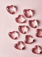 Fototapeta premium Clear Pink Heart-Shaped Gummies: a few clear, heart-shaped gummies scattered across the frame. The gummies are a soft, translucent pink, with a glossy, delicate texture that highlights their sweetness