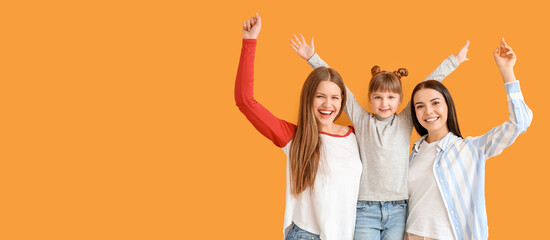 Happy lesbian couple with little adopted girl on color background