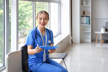 Female medical intern writing in clipboard at hospital