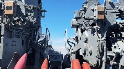 Detailed view of military ship artillery and equipment under a clear sky
