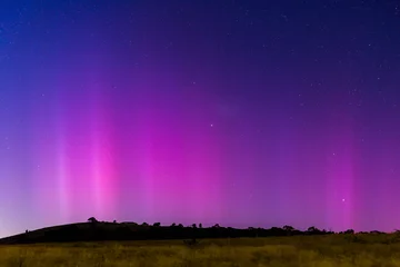 Gordijnen Aurora Australis display lights up the predawn sky in pinks © Merrillie
