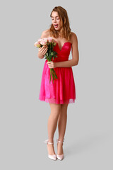 Young woman with roses on light background. Valentine's Day celebration