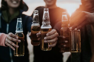 Happy friends toasting beer bottles
