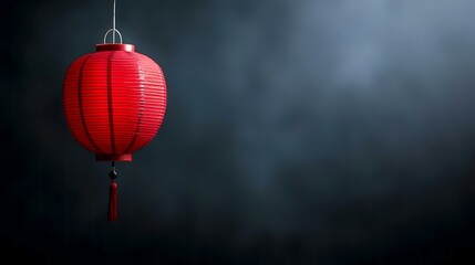Obraz premium Red paper lantern hangs against smoky dark background, ideal for festival or celebration design