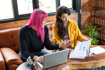 LGBTQ+ transgender man Beautiful Authentic Specialist with Pink Hair and Non-binary trans working together Working Design in creative workplace team work colleagues Gender equality