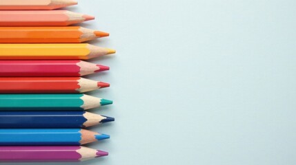 Fototapeta premium A Vibrant Row of Colored Pencils on a Light Blue Background, Perfect for Artistic Projects and Creative Designs