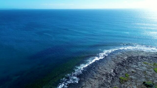 Drone aerial landscape Bawley Point headland ocean coastline horizon with waves breaking on rocky reef South Coast Shoalhaven Australia travel swimming tourism