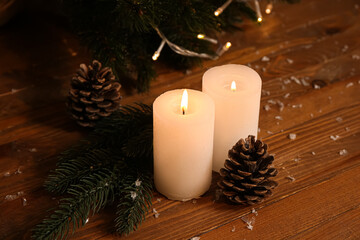 Composition with wax candle, fir branch and pine cones on table
