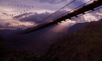 Experience the Majestic Bridge Mindfully Placed Over a Serene Mountainous Landscape at Dusk