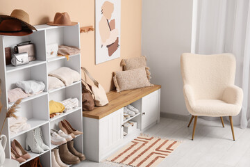 Stylish interior of dressing room with folded clothes, shoes and accessories