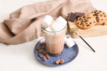 Glass of sweet chocolate milk with marshmallows and tasty cookies on white background