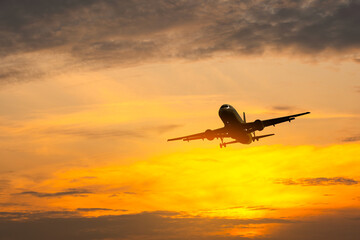 Passenger plane flying in the sky at sunrise. Airplane flying over mountains. Travel concept by plane and international travel.