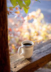 Cup of coffee outside a cabin in the morning