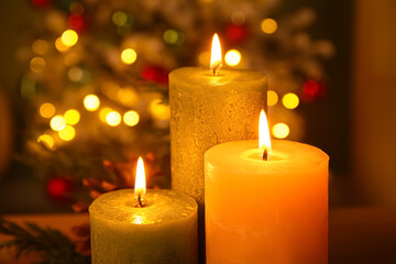 Burning candles against Christmas tree in evening, closeup