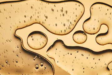 The beautiful texture of the cosmetic serum on a gold background that takes up most of the photo.