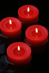 Four lit red candles floating in water, creating a serene ambiance.