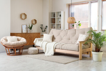 Interior of living room with sofa, knitted blanket and armchair