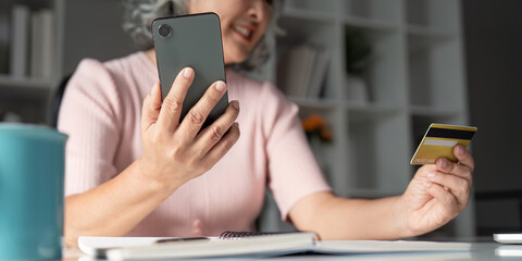 Elderly online shopping session home office digital payment cozy environment close-up credit card use