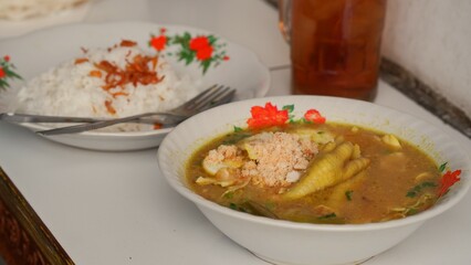 Chicken soup with shredded chicken, chicken feet, eggs, sliced cabbage, vermicelli in broth. Indonesia food.