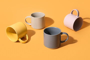 Ceramic cups on orange background