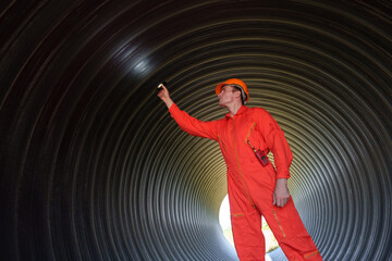 Male mechanical engineer wearing safety uniform inspects and inspects piping system of new...