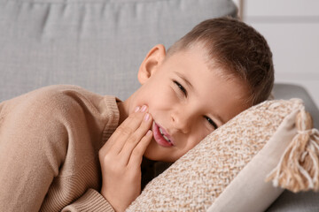 Little boy suffering from toothache at home