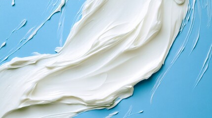 8.A close-up of a creamy white smear with smooth, wavy textures placed centrally on a vibrant blue background, highlighting the rich and luxurious consistency of the product.