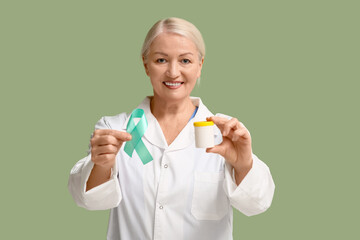 Mature female doctor with teal ribbon and pills on green background. Cervical Health Awareness Month