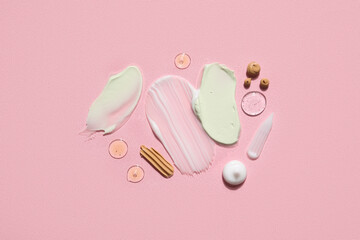 Composition with samples of different cosmetic products on pink background