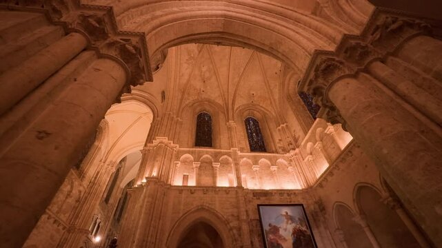 Low angle cinematic shot capturing painted windows of Saint-Nicolas Church in Blois, France. Big, tall pilars.