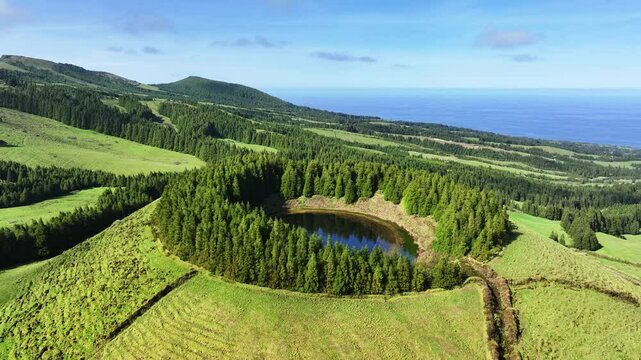 Scenic Pau Pique lake surrounded by trees on Sao Miguel, Azores. Aerial