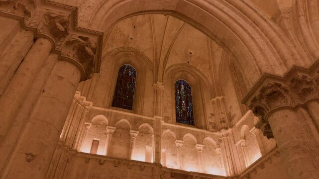 Low angle shot of windows of Saint-Nicolas Church in Blois, France with vintage architecture pillars. Lit up church.