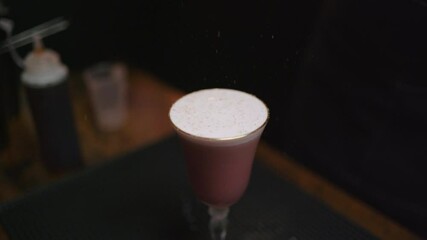 Decorating a beautiful cocktail with cinnamon. Crafting cocktails at home with precision and flair. Perfect for bartender training videos or social media content. Slow Motion.