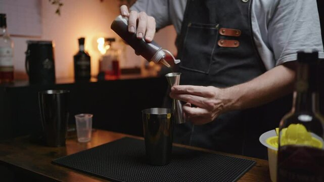 Home bartender skillfully pouring syrup into cocktail. Ideal for mixology tutorials or beverage commercials.