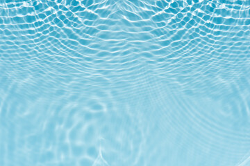 Obraz premium Blue water with ripples on the surface. Defocus blurred transparent blue colored clear calm water surface texture with splashes and bubbles. Water waves with shining pattern texture background.
