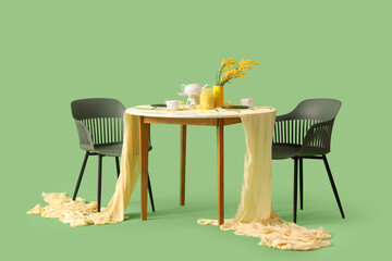 Served restaurant table with flowers on green background