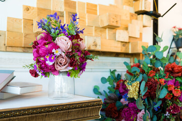 A fake flower bouquet in a vase on the table decorates the room.