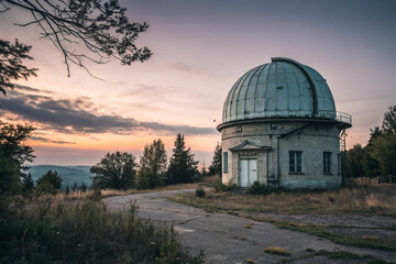 Obraz premium Abandoned observatory at sunset with dome and surrounding trees