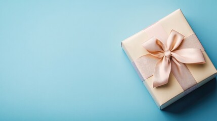 Elegant gift box with a satin bow on a serene blue background ideal for celebration themes and customizable space for text or messages.