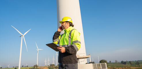 Engineer wearing uniform inspection and survey work in wind turbine farms rotation to generate...