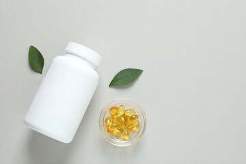 White bottle on a gray background. Fish oil tablets. Biologically active additives. Omega 3, 6,...