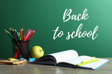 Back to school concept. Close-up of colorful stationery, textbooks on green chalkboard background
