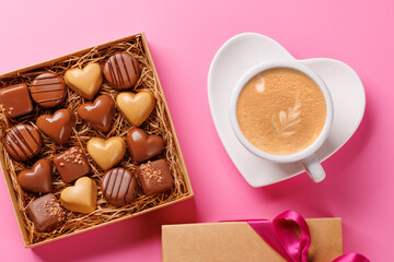 A romantic Valentines Day setup featuring a box of assorted chocolates and a steaming cup of coffee