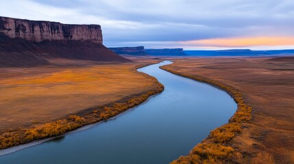 Breathtaking River Meandering Through Lush Green Valley Surrounded by Majestic Mountains Under Clear Blue Sky in Nature