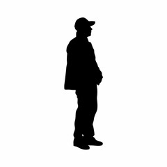 A man is standing in front of a white background. He is wearing a hat and shorts. He is wearing a black shirt